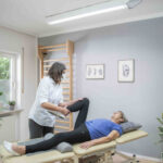 Physiotherapie bei einer Frau am Fußgelenk